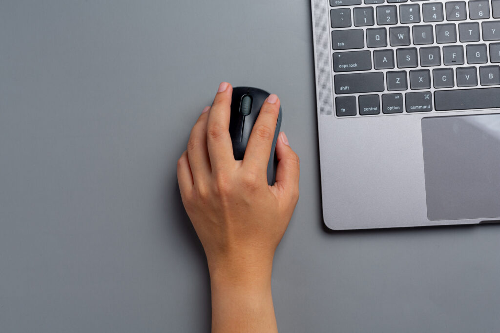 woman works with laptop home holds computer mouse her left hand